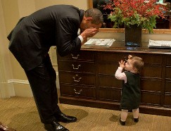 30 Oct 2009, Washington, DC, USA --- "Washington, DC - October 30, 2009 -- United States President Barack Obama plays peek-a-boo with Maeve Beliveau, the daughter of Director of Advance Emmett Beliveau, in the Outer Oval Office, October 30, 2009. Mandatory Credit: Pete Souza - White House via CNP" --- Image by © Pete Souza/White House/Handout/CNP/Corbis